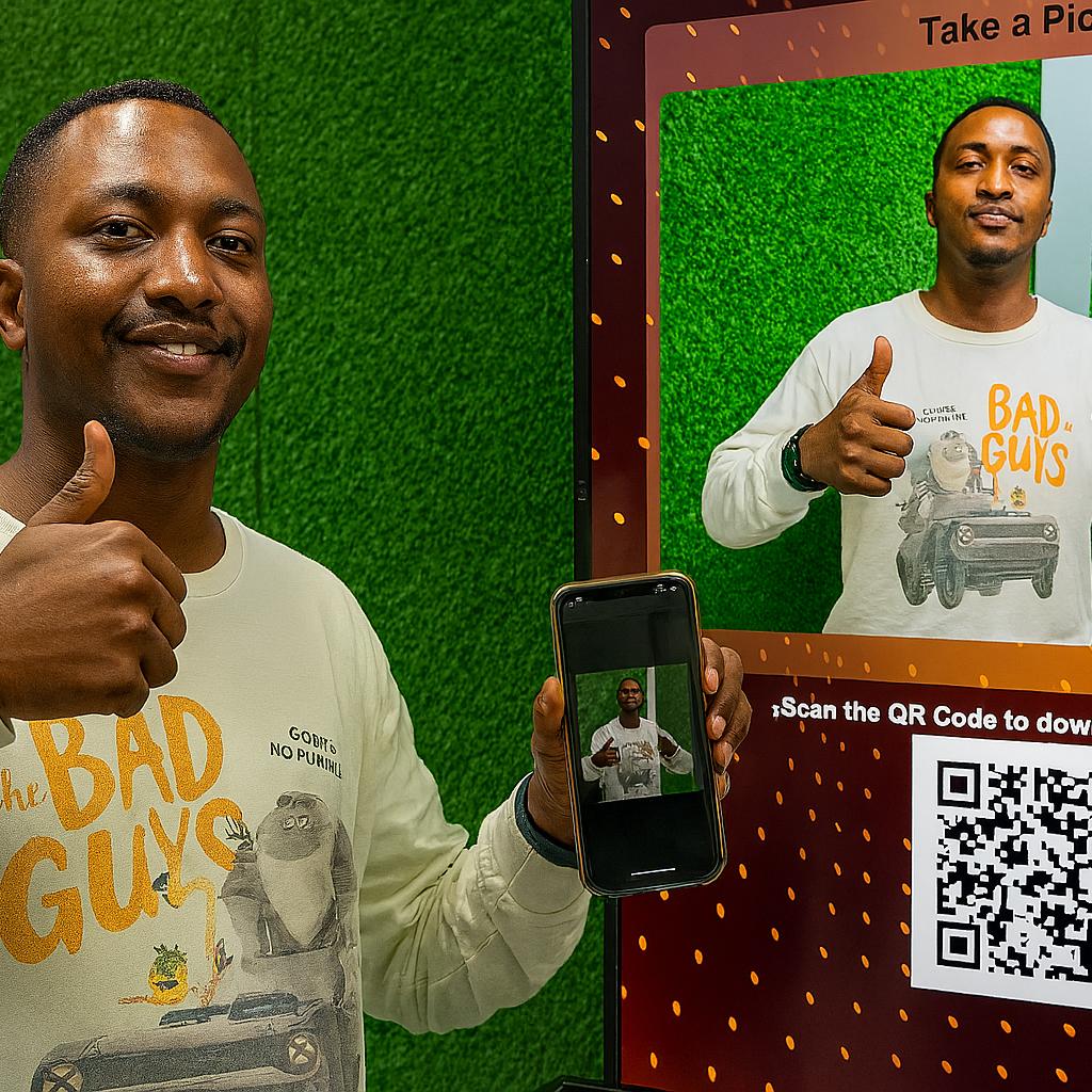 Guest playing interactive event game at exhibition booth in Dubai, pressing button to win prize, with branded screen display and selfie sharing feature for engagement.